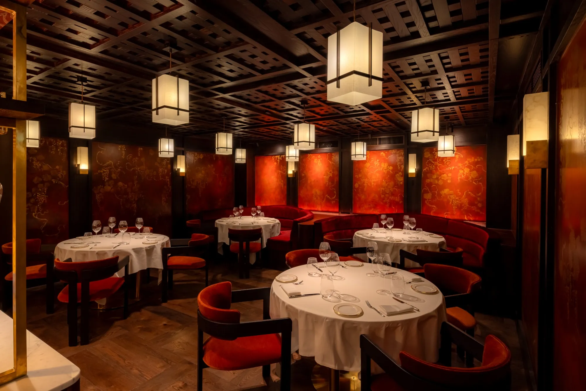Atmospheric Japanese restaurant dining area with red walls and warm hanging lantern lights